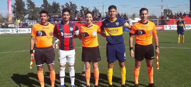 Emanuel Maciel, capitán de San Lorenzo junto a su rival y la terna arbitral. 